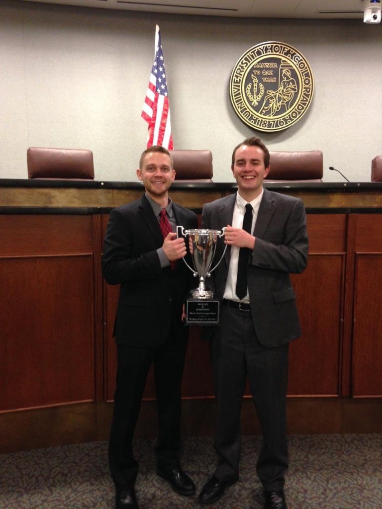 Attorneys holding up trophy